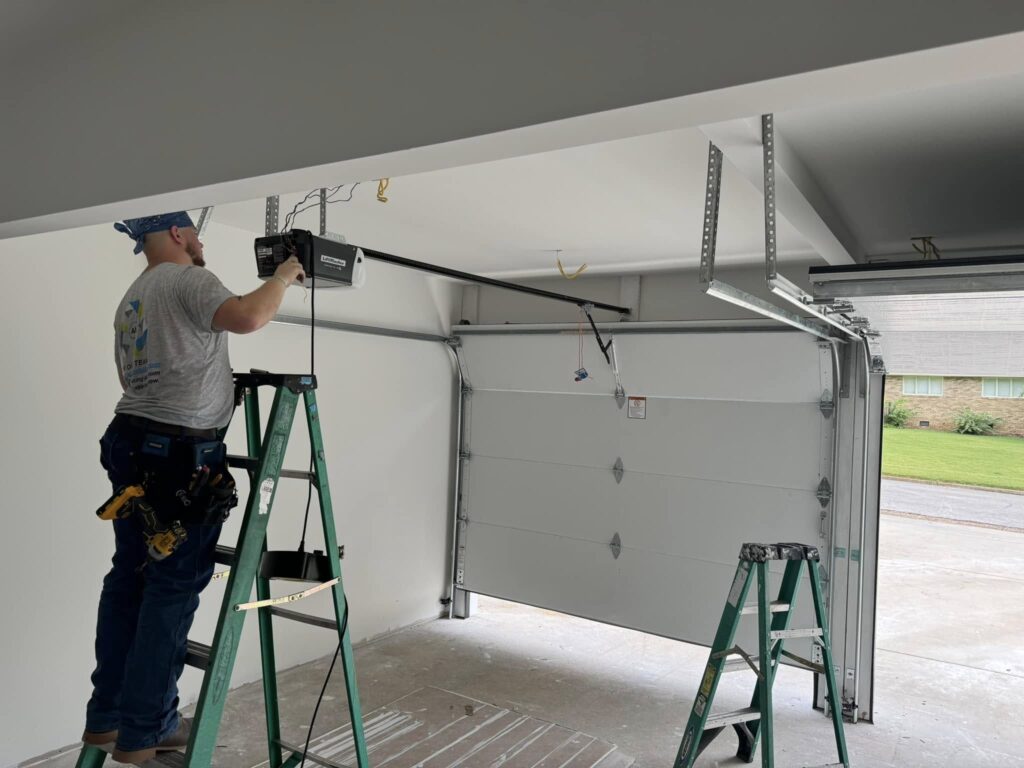 Best Door Co. technician tightening garage door hardware for homeowner in Florence AL