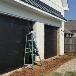 Garage door technician adjusting torsion springs at a Florence Alabama home